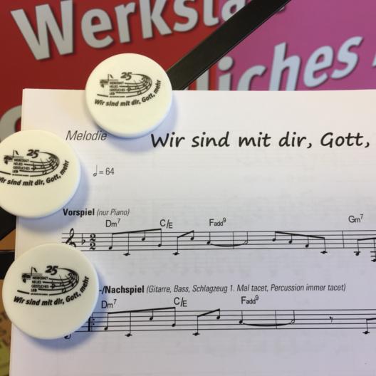 Arrangenmentheft mit Buttons auf einem Notenblatt
